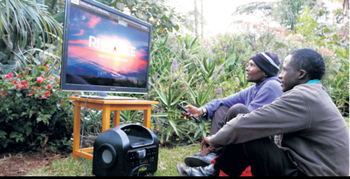 Two men watching a television powered by an AceOn portable power station outdoors